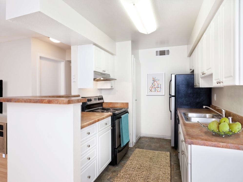 Classic Collection kitchen with white or metallic appliances, white cabinetry, and laminate countertops
