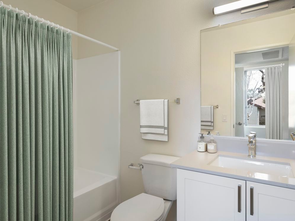 Renovated Package I bath with light grey quartz countertops and new white cabinetry
