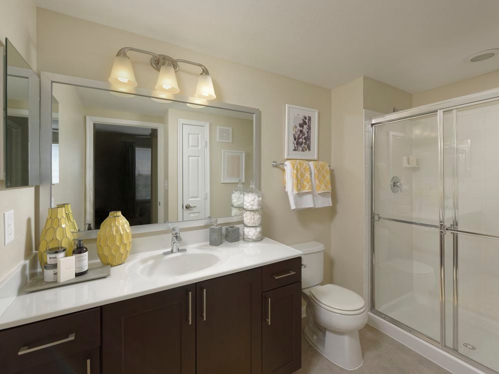 Espresso Package Townhome bathroom with espresso cabinetry, quartz countertop and shower with white tile backsplash