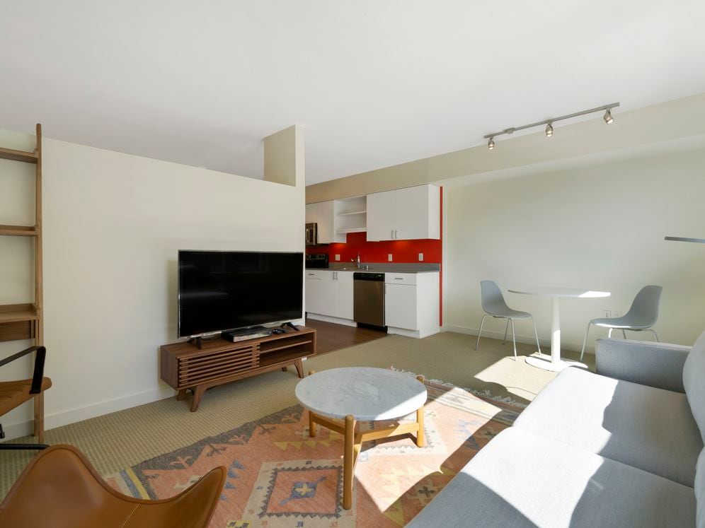 Furnished+ apartment homes come outfitted with a sofa, side chair, side table, coffee table, office chair, desk, TV stand and 50" Television (Representative Image – exact items and style of furnishings may vary)