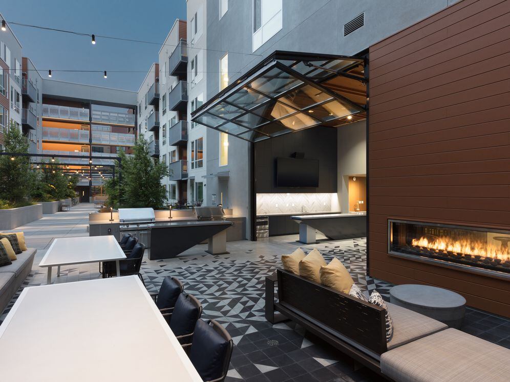 Outdoor resident lounge with common area seating, barbecue grills and fireplace
