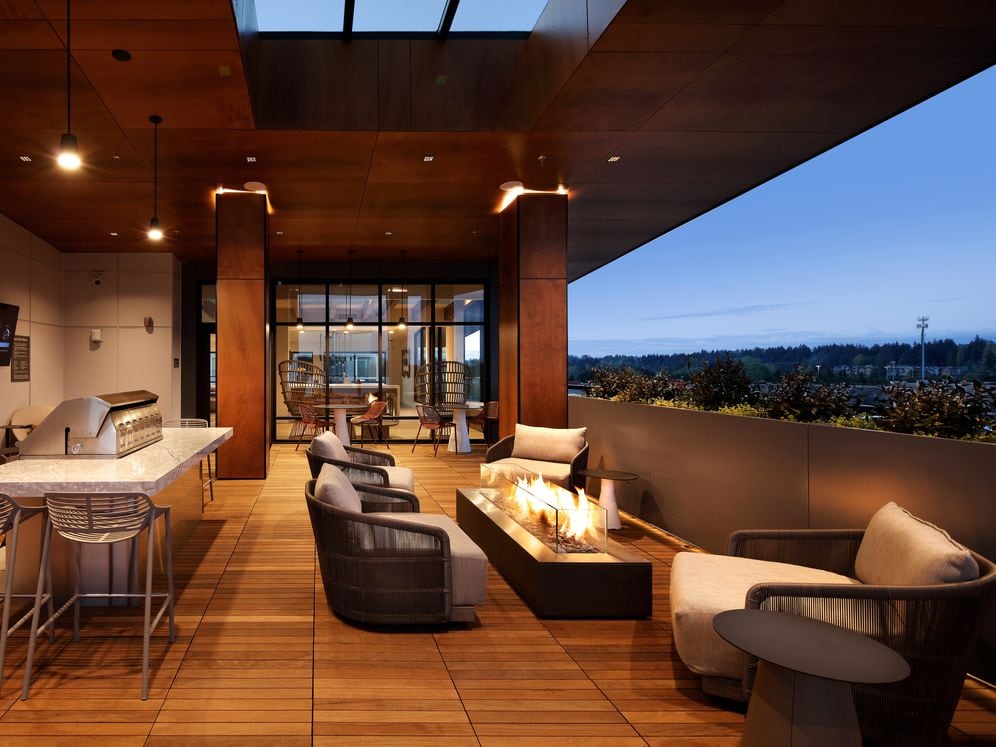 Outdoor terrace lounge with fire pit, lounge seating, and grills