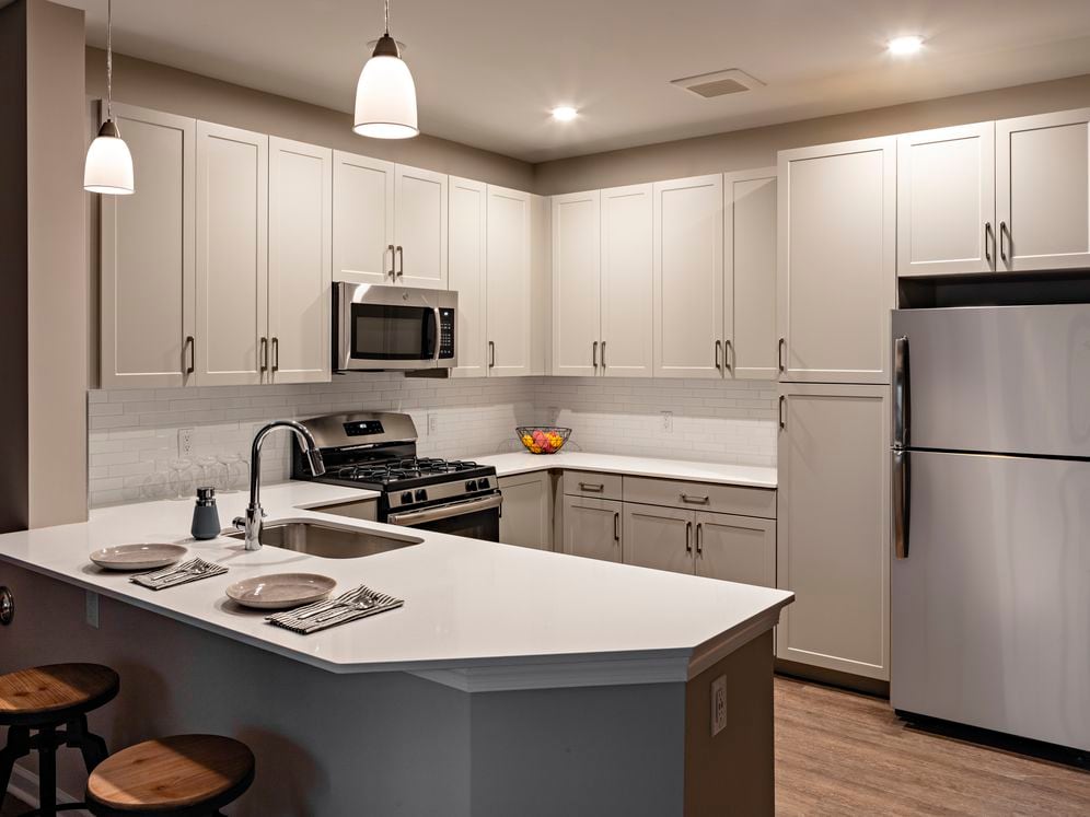 Modern kitchens with grey cabinetry, white quartz countertops, tile backsplash, stainless steel appliances, and hard surface flooring