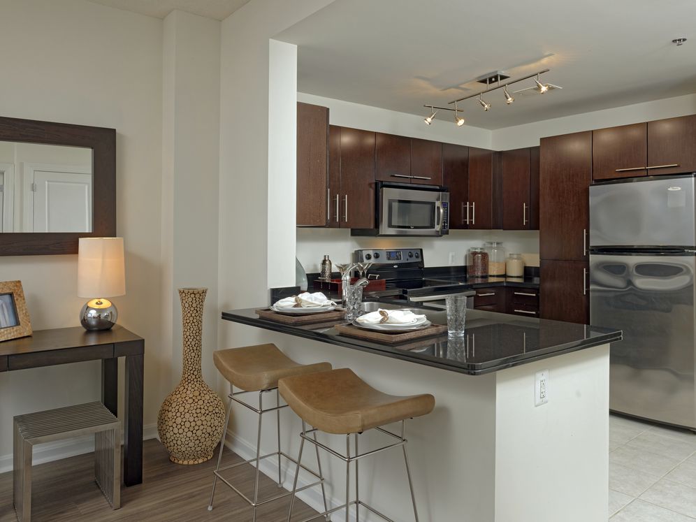 Dining area and open concept kitchen with black granite countertops, stainless steel appliances and hard surface flooring