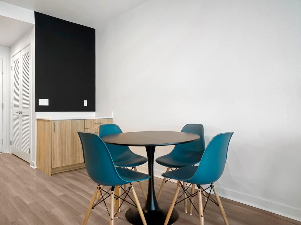 Furnished+ apartment homes include a dining set (Representative Image – exact items and style of furnishings may vary)