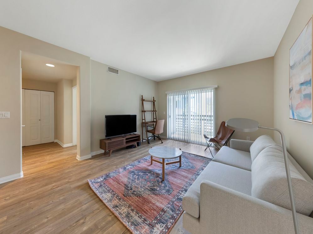 Furnished+ apartment homes come outfitted with a sofa, side chair, side table, coffee table, TV stand and 50" Television (Representative Image – exact items and style of furnishings may vary)
