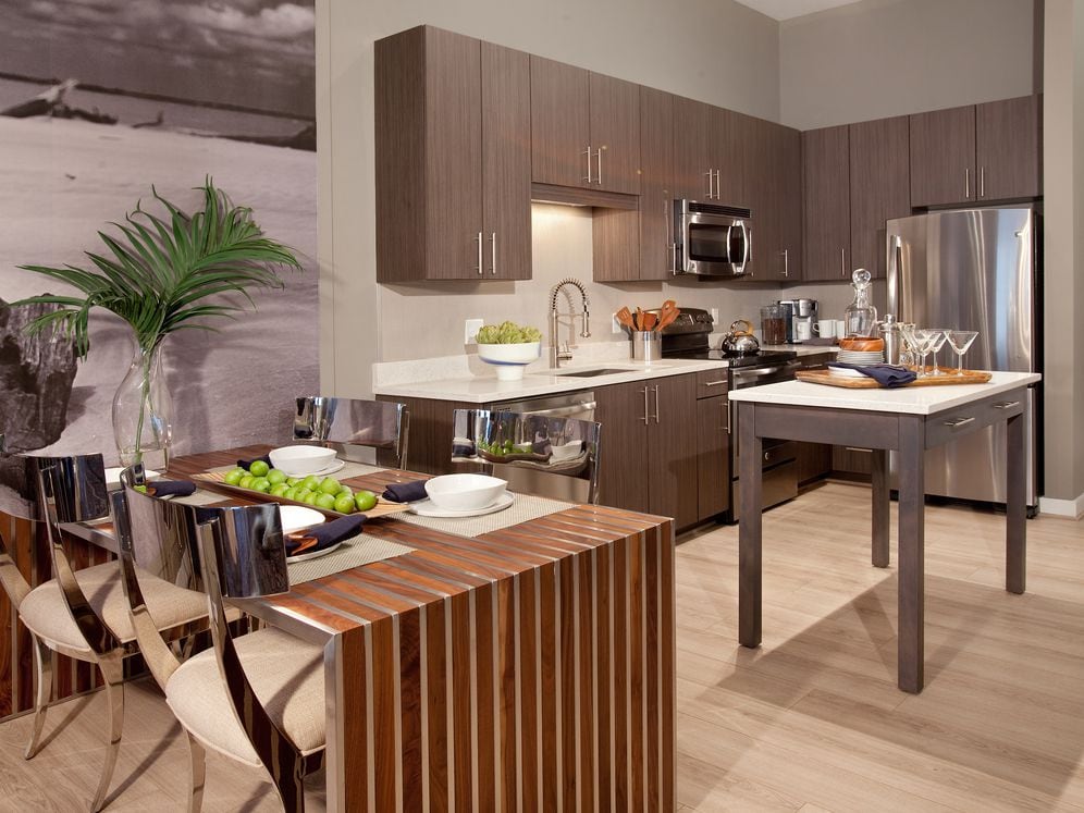 Dining area and open concept kitchen with quartz stone countertops, stainless-steel appliances, kitchen island and hard surface flooring