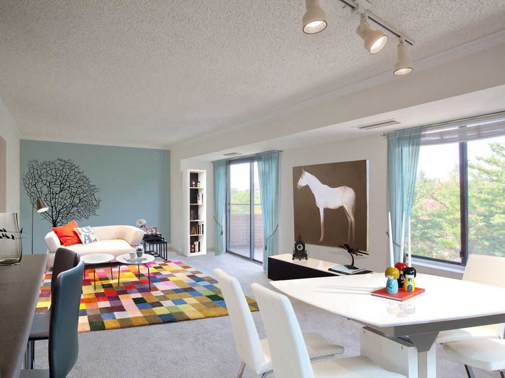 Living and dining areas with accent wall, balcony access and carpeted flooring
