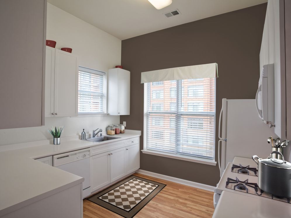 Classic I kitchen with white appliances, white cabinetry, and hard surface flooring