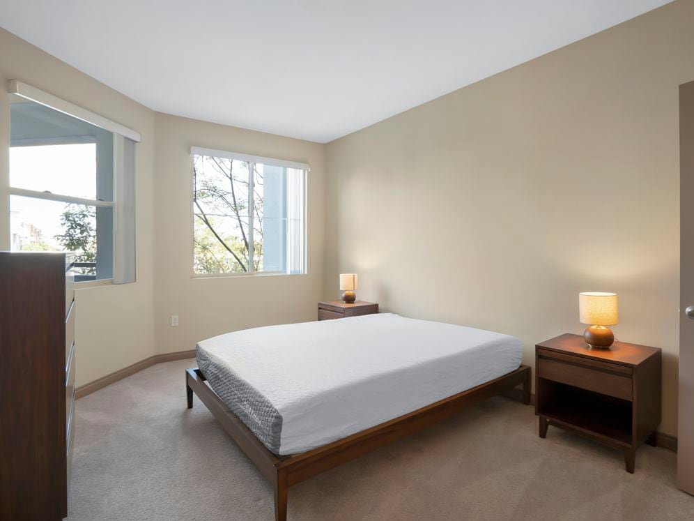 Furnished+ apartment homes feature queen bed with mattress, dresser, nightstands, and lamps (Representative Image – exact items and style of furnishings may vary)