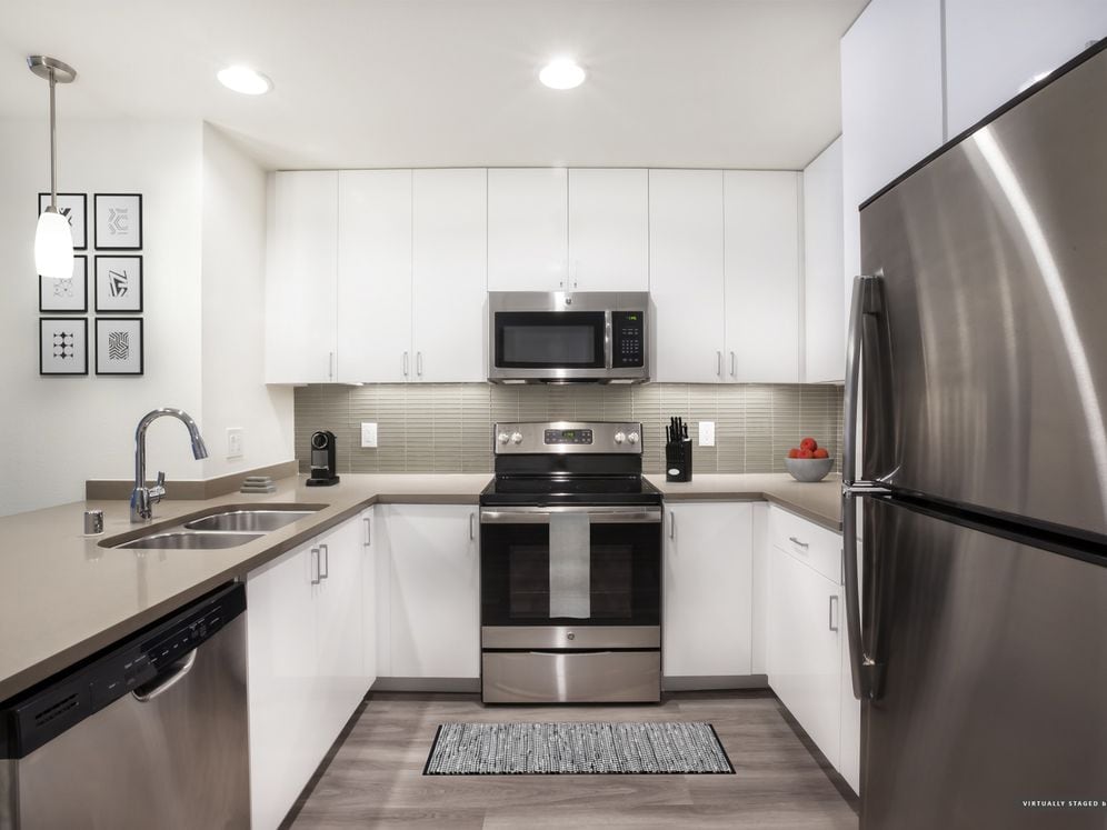 Modern Collection Kitchen with White Cabinetry Tile Backsplash Quartz Countertop Stainless Steel Appliances