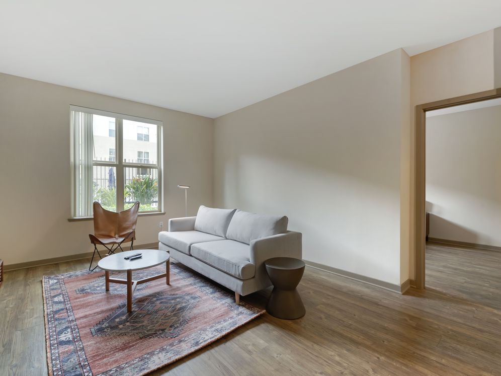 Furnished+ apartment homes come outfitted with a sofa, side chair, side table, coffee table, TV stand and 50" Television (Representative Image – exact items and style of furnishings may vary)