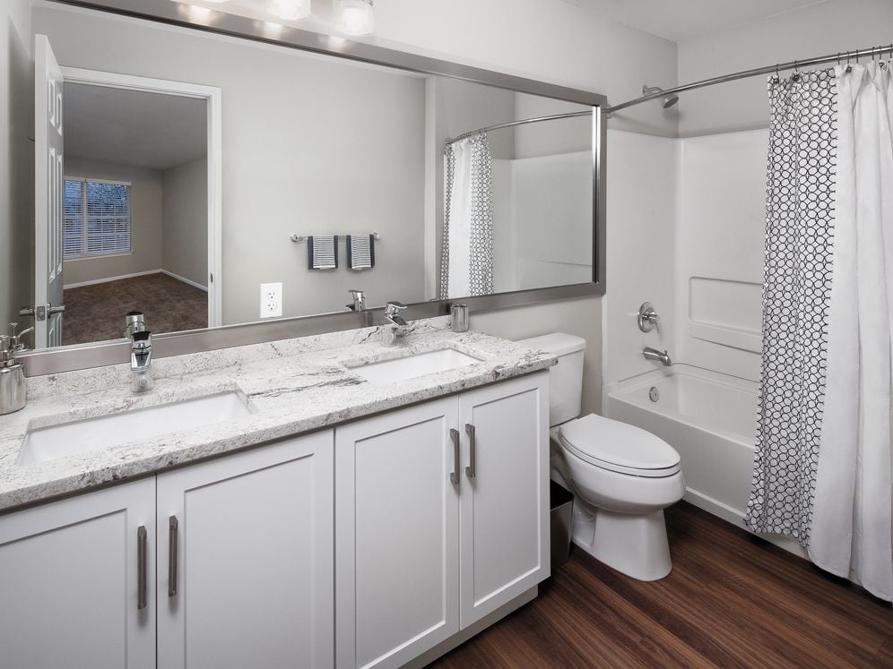 Upgrade Scheme I bath with beige speckled granite, white shaker cabinetry, and hard surface flooring