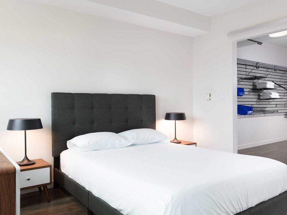 Furnished+ apartment homes feature queen bed with mattress, two pillows, dresser, nightstands, lamp, and mirror. (Representative Image – exact items and style of furnishings may vary)