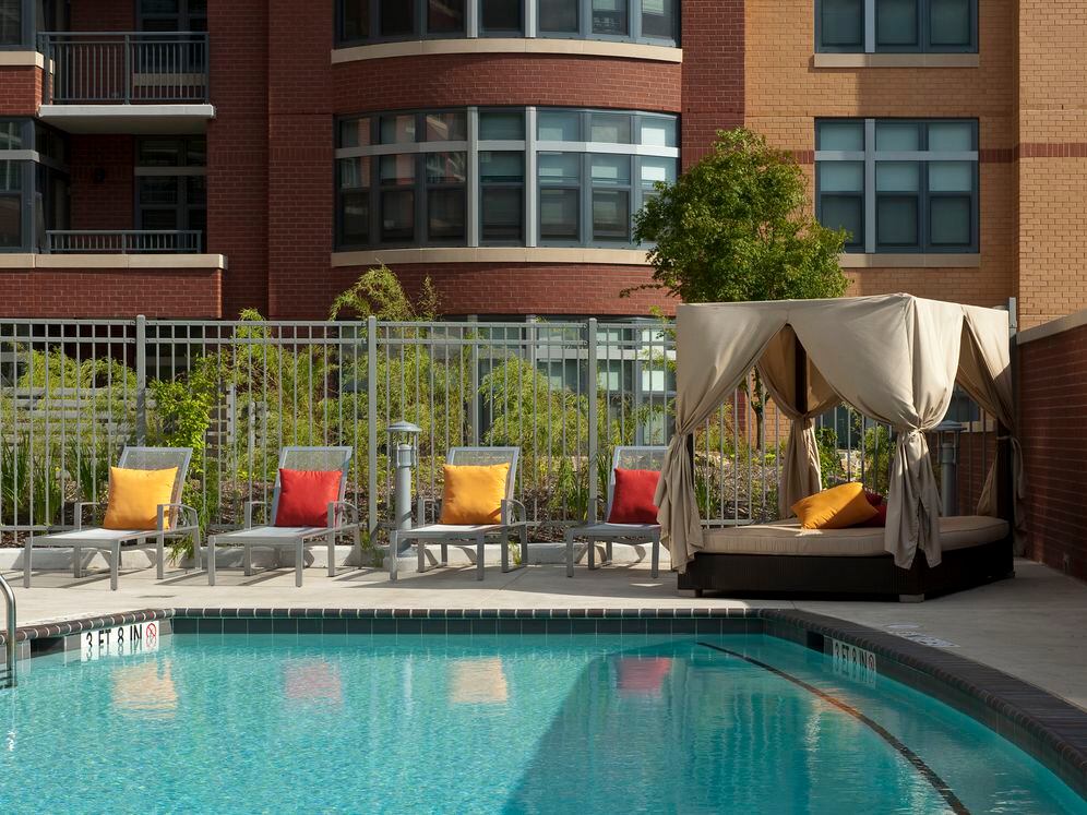 Swimming pool and sundeck with lounge seating and cabanas