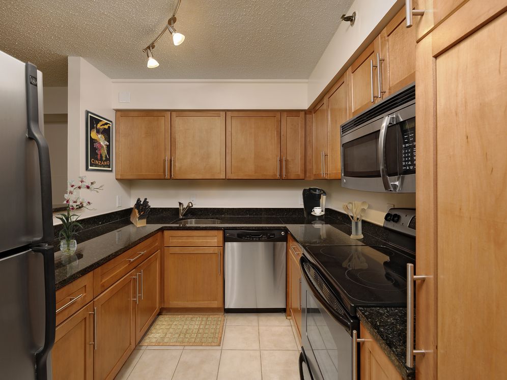 Kitchen with granite countertops, oak cabinetry, stainless steel appliances and tile flooring
